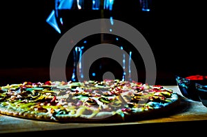 Red wine and delicious pizza with bacon, ham, mushrooms and mozzarella on a thin crust