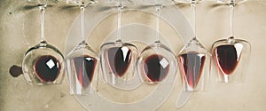 Red wine in different glasses over grey background