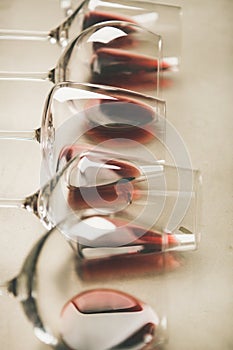 Red wine in different glasses over grey background, selective focus