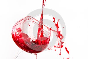 Red wine falling in a way splashing into a wine glass