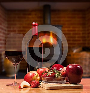 Red wine and fruit in front of burning fire