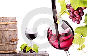 Red wine, glass and barrel with grapes