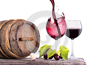 Red wine, glass and barrel with grapes