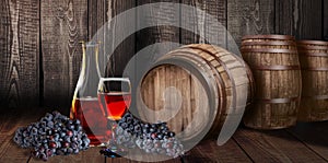 Red wine glass bottle with barrel on vineyard wood