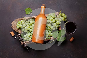 Red wine glass, bottle and white grape