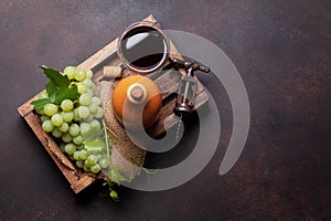 Red wine glass, bottle and white grape in wooden box