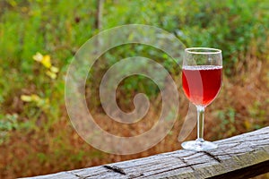 Red wine glass and bunch of grapes on wooden table