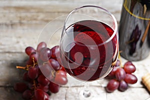 Red Wine Glass And Grapes On Wooden Table