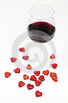 Red wine glass and red hearts isolated on white background - romantic seduction - valentines day