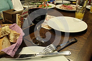 Red wine in a glass in a restaurant near a plate of bread on a dark background of the table. Restaurant cafe