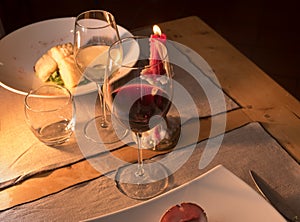 Red wine glass with white wine glass on rustic trattoria table set