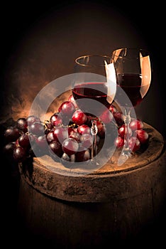 Red wine glass on wooden barrel