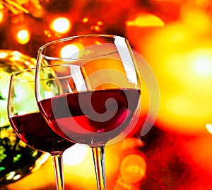 Red wine glasses against colorful unfocused lights background photo