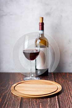 Red wine glasses and bottle on wooden background