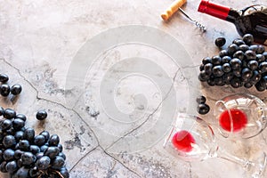 Red wine, glasses and grapes on a marble background with space for text