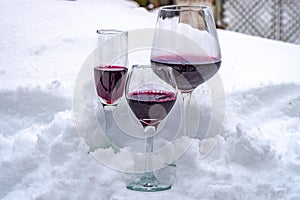 Red wine glasses on snow