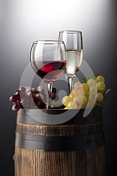 Red wine glasses and white wine glasses with red and green vine on old wooden barrel