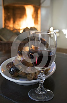 Red wine goblet and roast piglet round the fireside