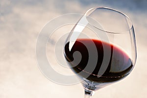 Red wine from grape varieties merlot in glass, gray table, selective focus, shallow DOF