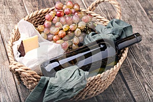 Red wine, grapes and cheese in basket