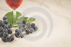 Red wine and grapes/Glass of red wine and grapes on a white marble background. Copy space