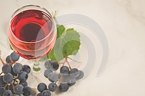 red wine and grapes/Glass of red wine and grapes on a white marble background. Top view