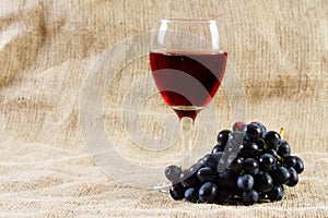 Red wine and grapes on vintage background