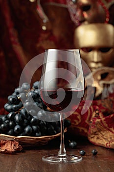 Red wine, grapes, and vintage carnival masks