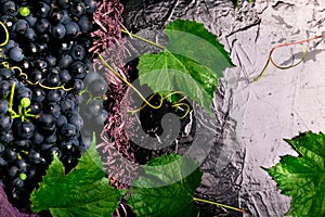 Red wine grapes in voiolet basket on bllack background.