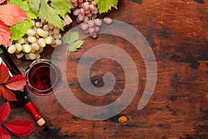 Red wine and grapes on wooden table