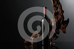 Red wine and old snag on a black background