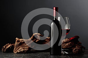Red wine and old weathered snag on a black stone table