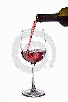 Red wine is poured into a glass from a bottle, isolate on a white background.