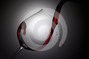 Red Wine Poured into a Wine Glass with Drops photo