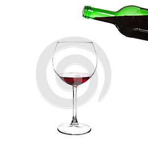 Red wine pouring from bottle into big glass