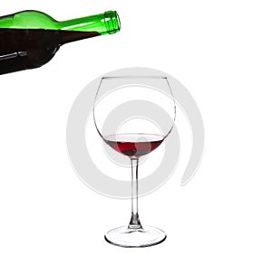 Red wine pouring from bottle into big glass on white