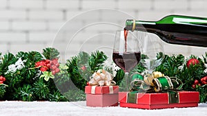 Red wine is pouring from bottle in to glass decorating with red