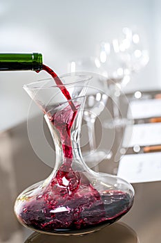 Red wine pouring into decanter at wine tasting.