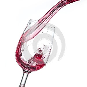 Red wine pouring into glass isolated on white background