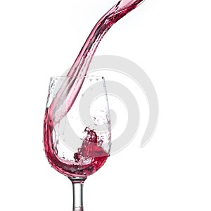 Red wine pouring into glass isolated on white background