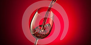 Red wine pouring into a glass on red background