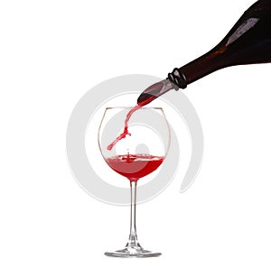 Red wine pouring into wine glass isolated