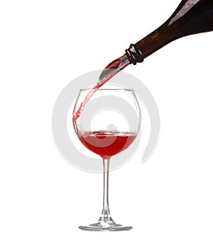 Red wine pouring into wine glass isolated