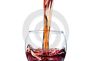 Red wine pouring into wine glass isolated on white background.