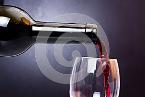 Red wine pours into glass close-up. Wine pouring to clean glass