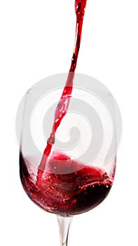 Red wine pours into a tall glass