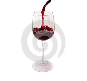 Red wine pours into a tall glass