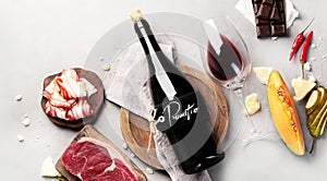 Red wine Primitivo with appetizers on gray background photo