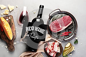 Red wine Primitivo with appetizers on gray background photo