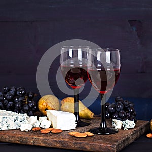Red wine and snacks. Wine, grapes, cheese, nuts, olives. Romantic evening, still life.